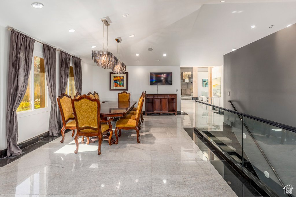 Dining space featuring granite floors, a chandelier, recessed lighting, lofted ceiling, and baseboards