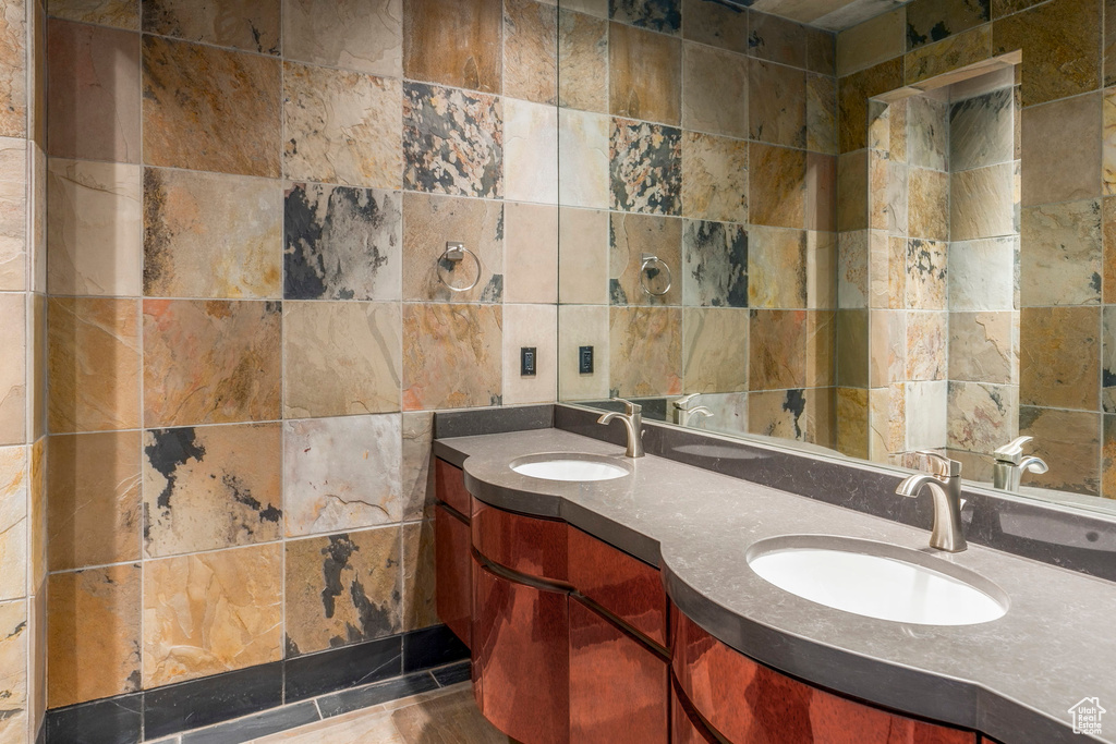 Full bath with tile walls and double vanity