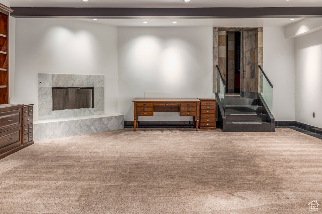 Carpeted living area featuring recessed lighting, a high end fireplace, stairway, and baseboards