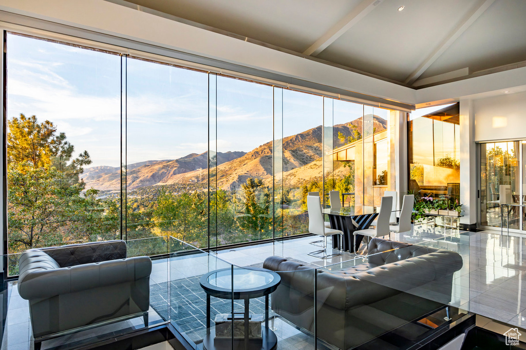 Living room with lofted ceiling, a mountain view, and plenty of natural light