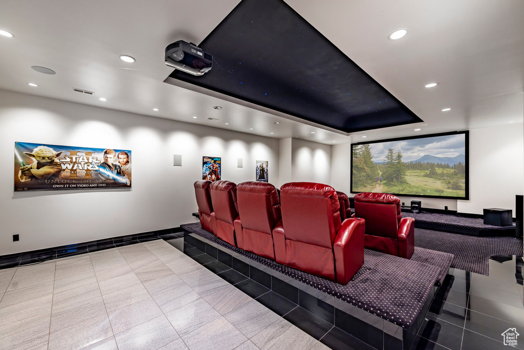 Tiled cinema featuring recessed lighting, a tray ceiling, and baseboards