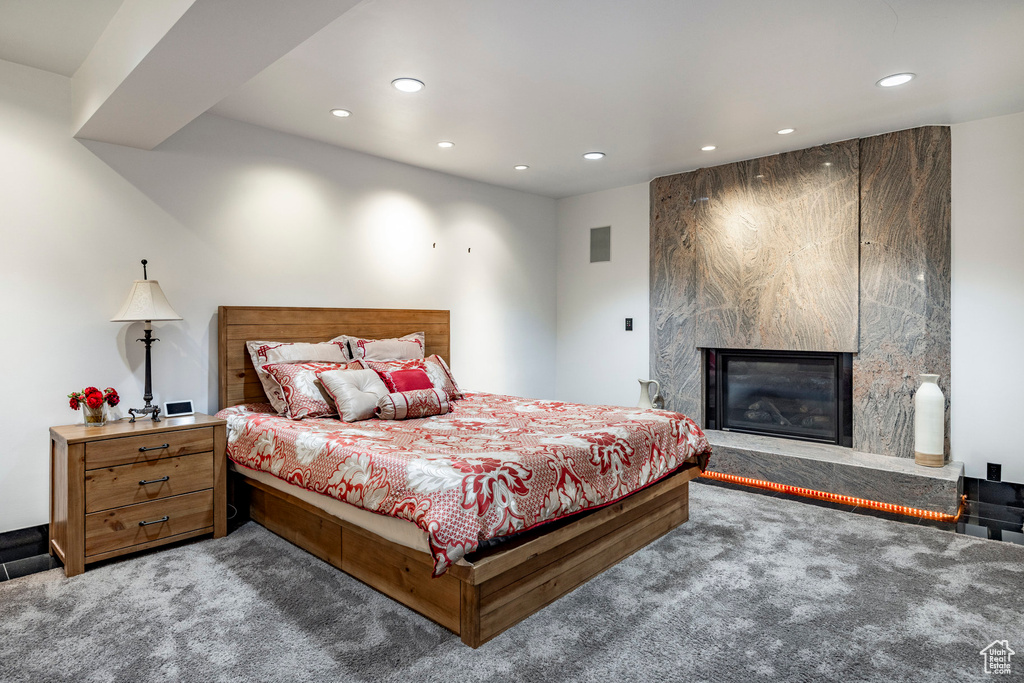 Carpeted bedroom with recessed lighting and a fireplace