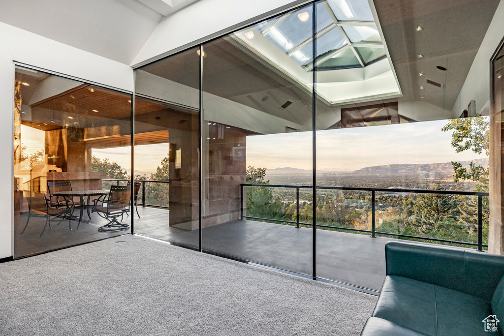 Interior space featuring a skylight, a mountain view, a high ceiling, and expansive windows