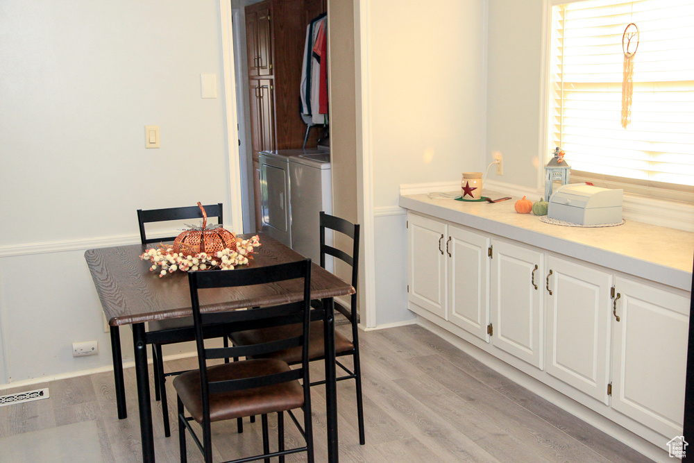 Dining space featuring washer and clothes dryer and light hardwood / wood-style floors