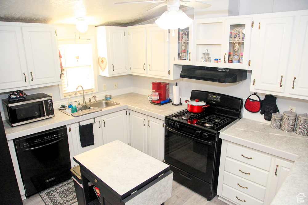 Kitchen featuring a textured ceiling, black appliances, white cabinetry, and sink