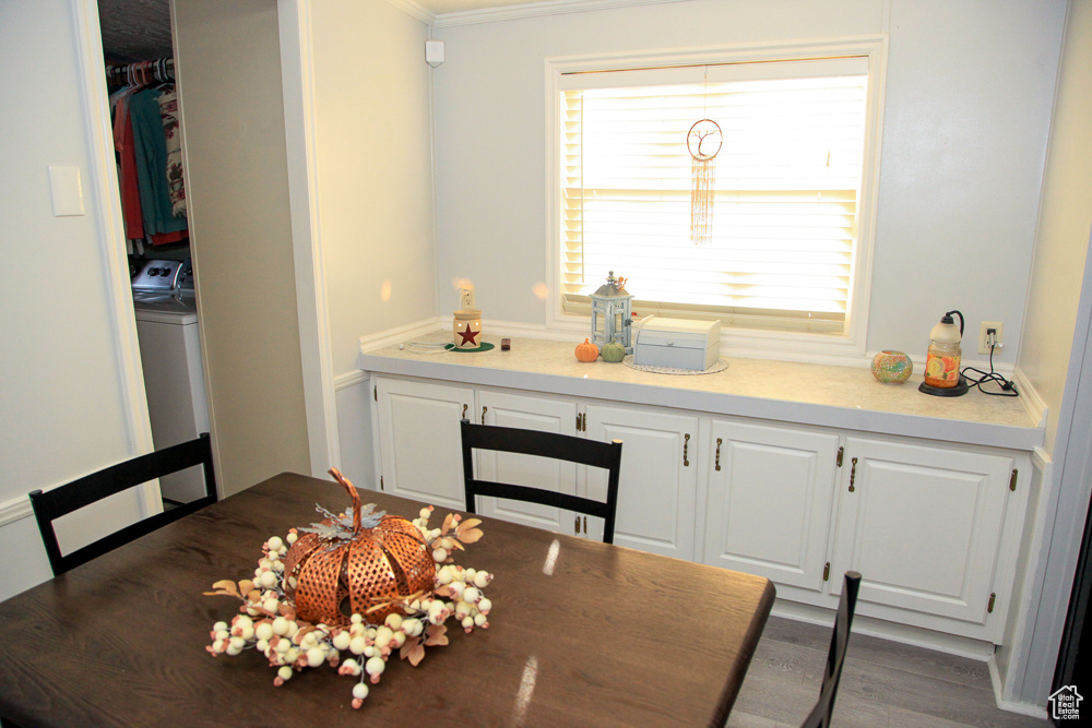 Dining area with crown molding, washer / dryer, and hardwood / wood-style flooring