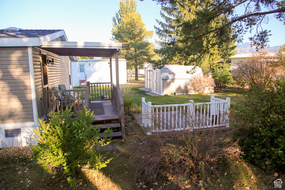 View of yard with a storage shed and a deck with mountain view