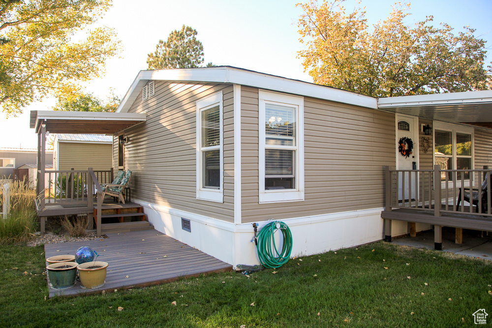 Exterior space with a yard and a wooden deck