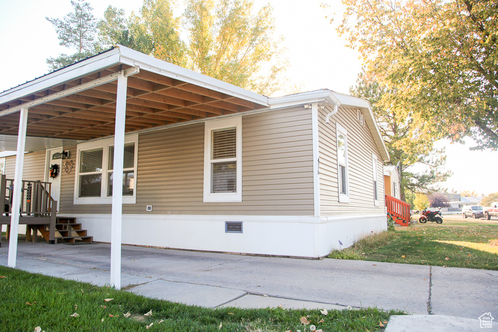 View of side of home featuring a carport and a yard