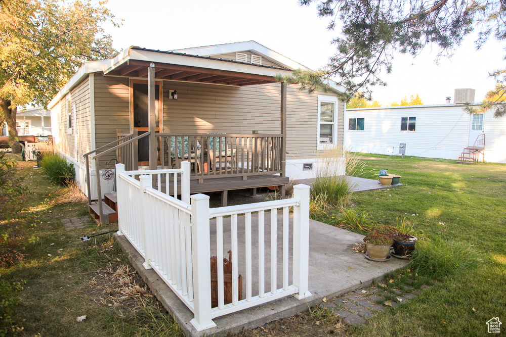 Rear view of property with a lawn and cooling unit