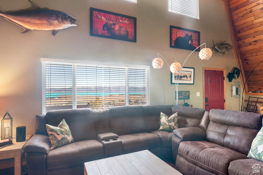 Living room with wood ceiling, electric panel, and high vaulted ceiling