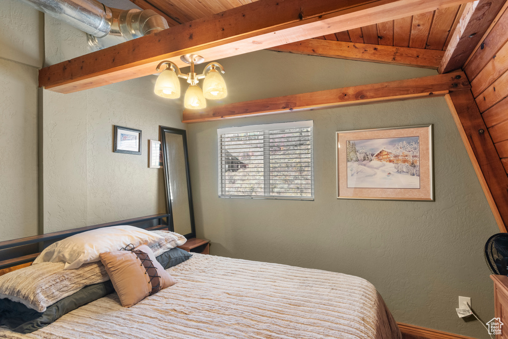 Bedroom featuring wood ceiling, lofted ceiling with beams, and an inviting chandelier