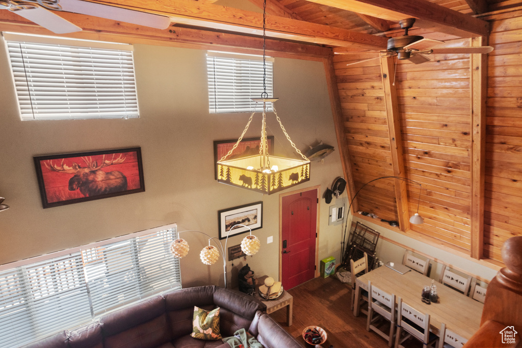 Living room with lofted ceiling with beams, ceiling fan, wooden ceiling, and hardwood / wood-style floors