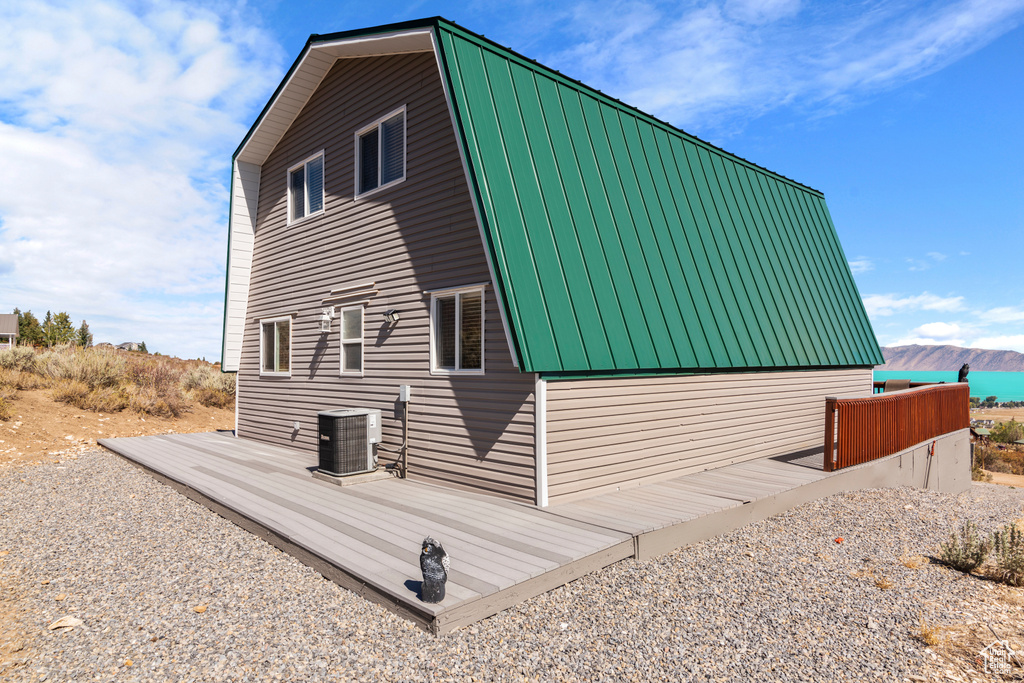 View of home's exterior with a deck with mountain view and central air condition unit