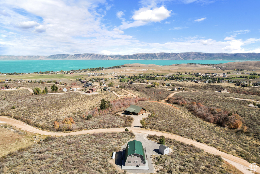 Birds eye view of property with a water and mountain view