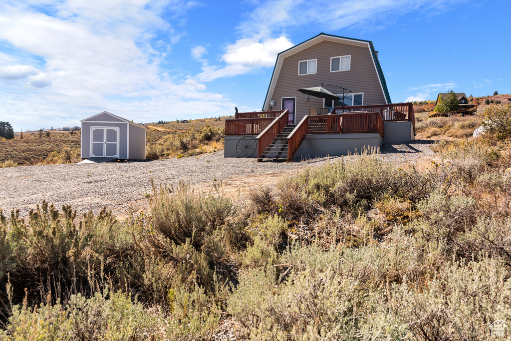 Rear view of house featuring a storage shed and a deck