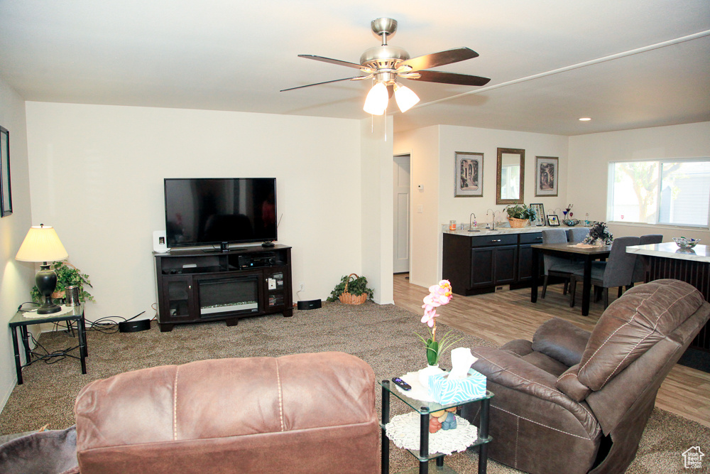 Living room featuring ceiling fan and light colored carpet