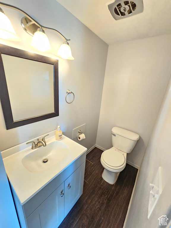 Bathroom featuring hardwood / wood-style floors, vanity, and toilet