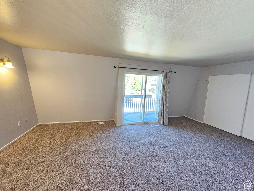 Carpeted empty room with a textured ceiling