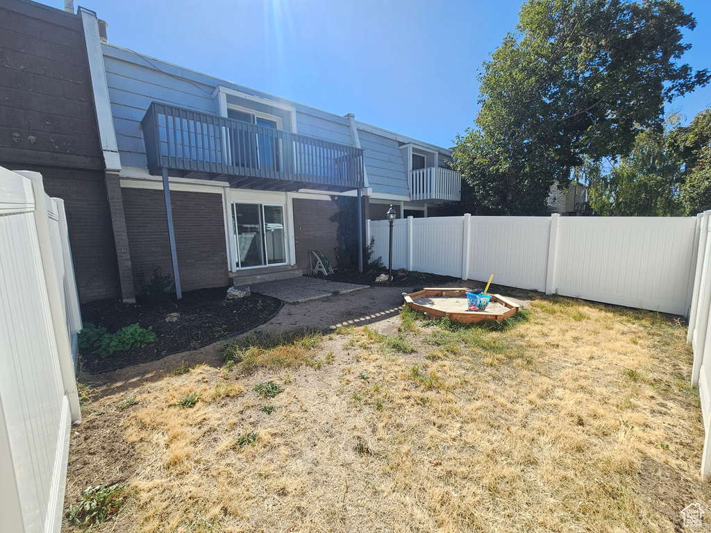 View of yard featuring a balcony and a fire pit