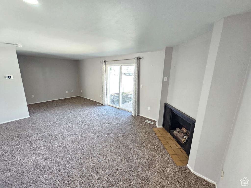 Unfurnished living room featuring carpet floors