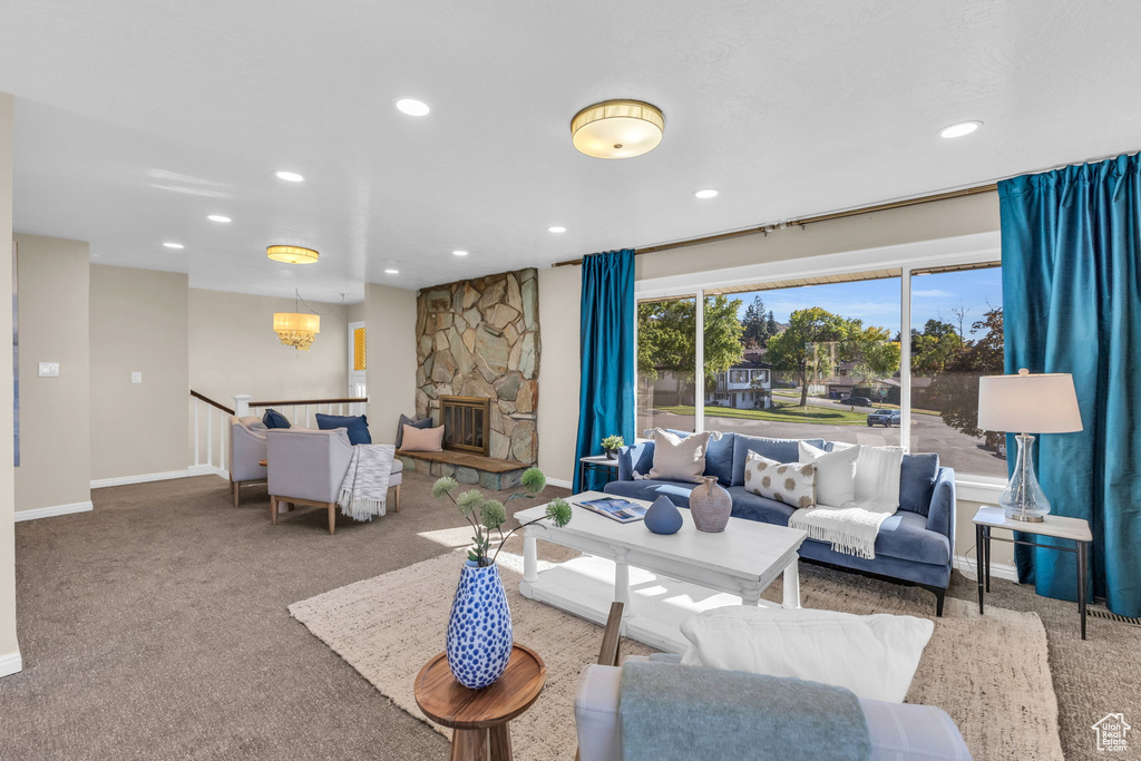 Living room with carpet floors, a fireplace, and a chandelier