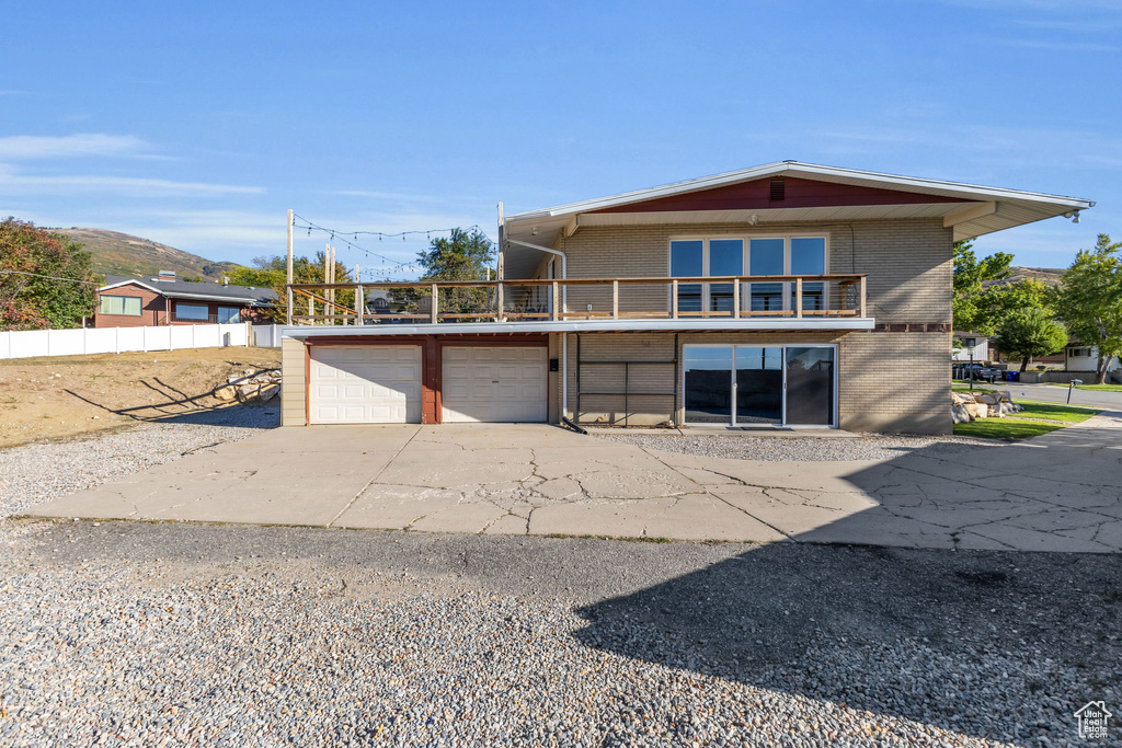 View of front of house featuring a balcony and a garage