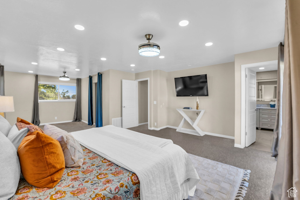 Bedroom with ensuite bath and dark colored carpet