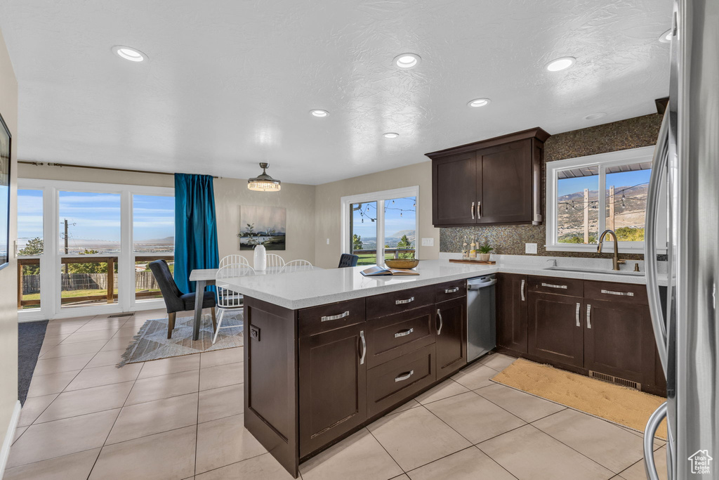 Kitchen with kitchen peninsula, stainless steel appliances, and plenty of natural light