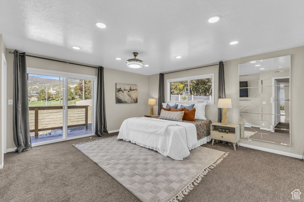 Carpeted bedroom featuring ceiling fan, a textured ceiling, and access to exterior