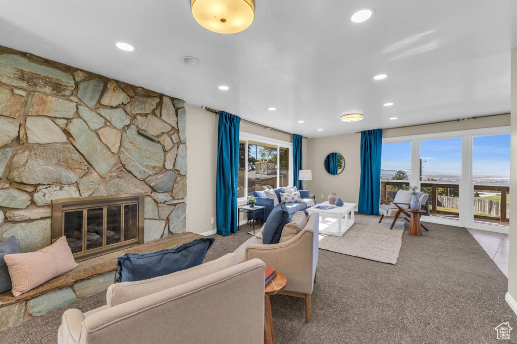 Carpeted living room featuring a stone fireplace