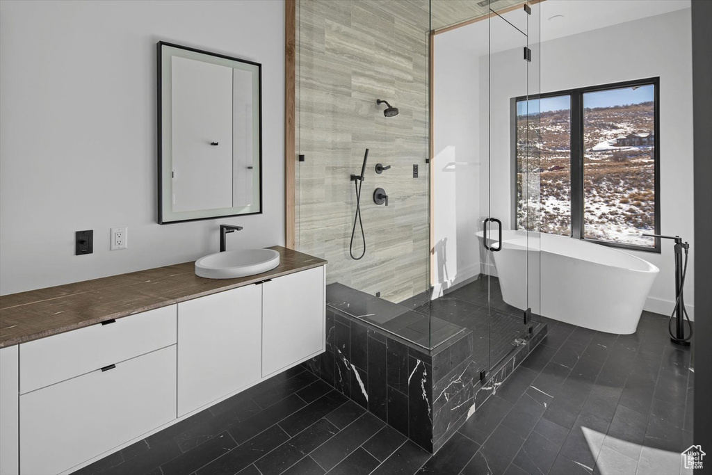 Bathroom featuring tile flooring, vanity, and a shower with door