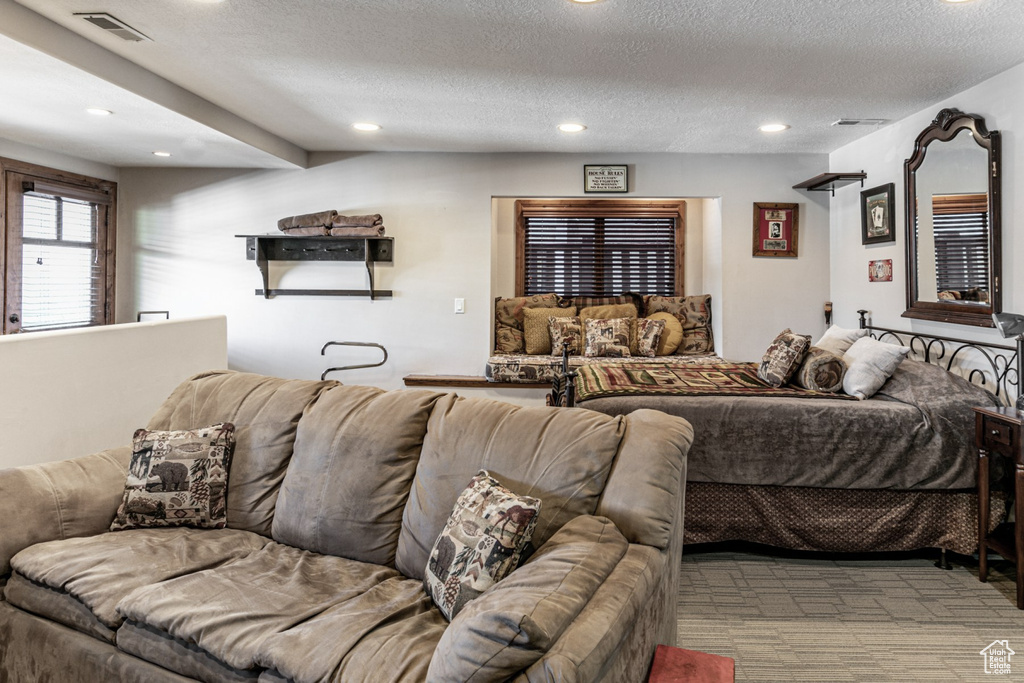 Bedroom with a textured ceiling and light colored carpet