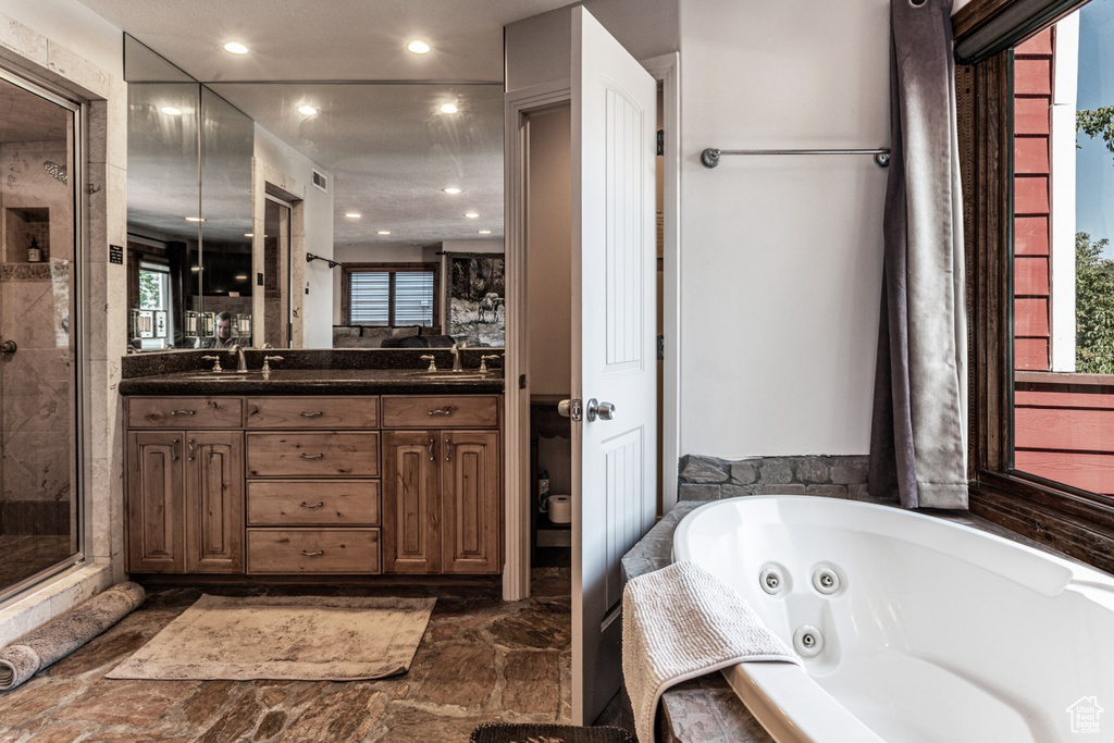 Bathroom with vanity and shower with separate bathtub