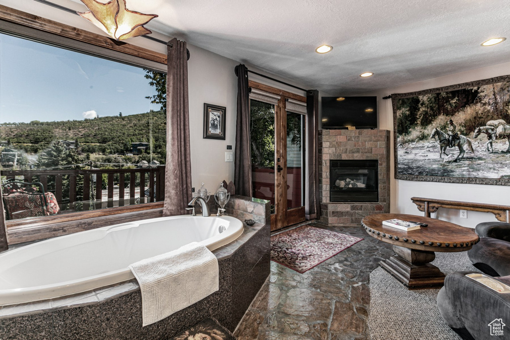 Bathroom featuring tiled tub and a textured ceiling