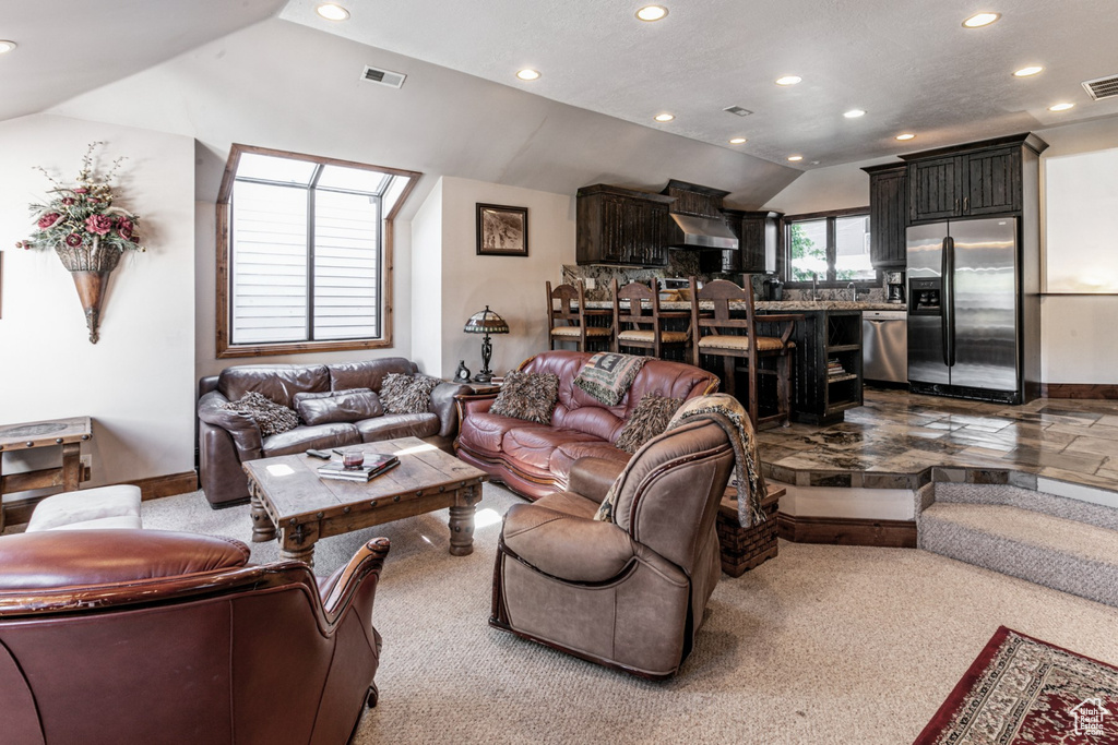 Carpeted living room with vaulted ceiling