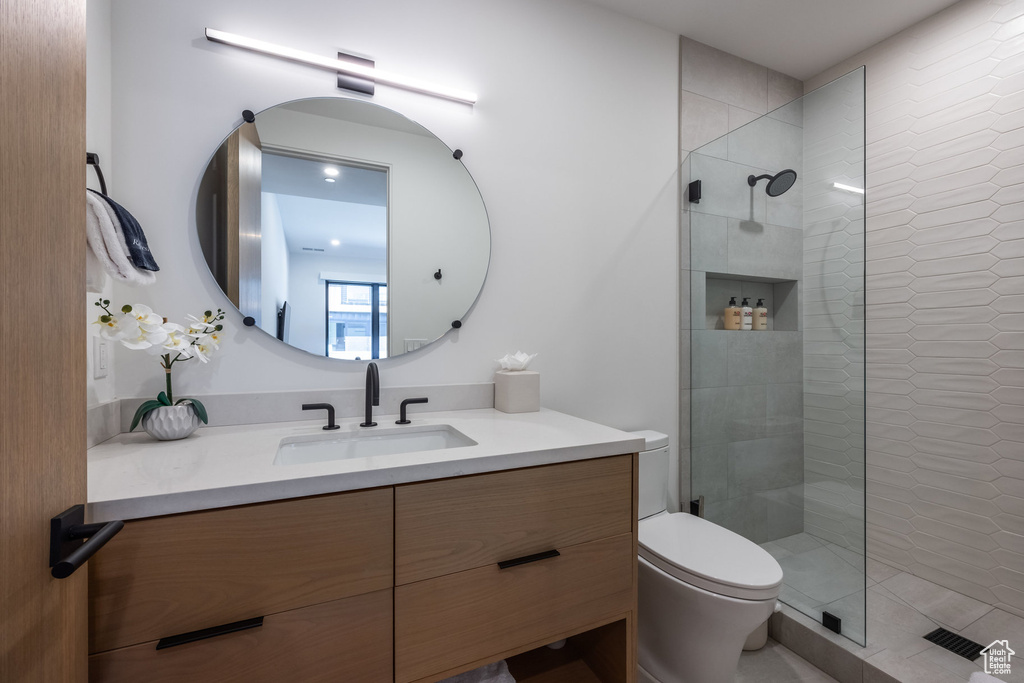 Bathroom with toilet, an enclosed shower, and vanity
