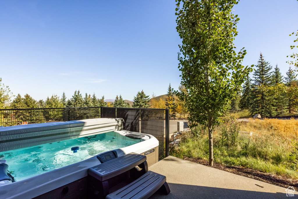 View of swimming pool with a hot tub