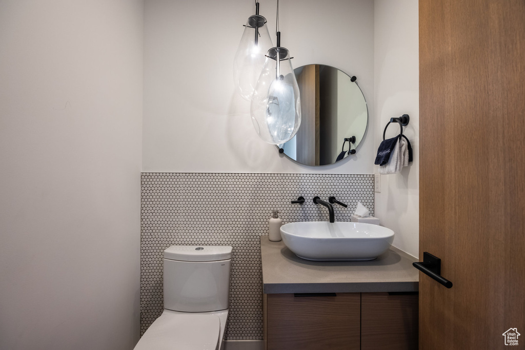 Bathroom with tasteful backsplash, vanity, and toilet