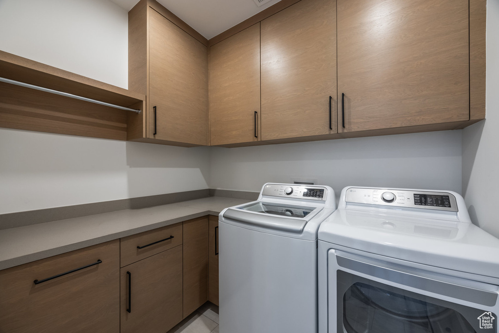 Laundry area featuring cabinets and separate washer and dryer