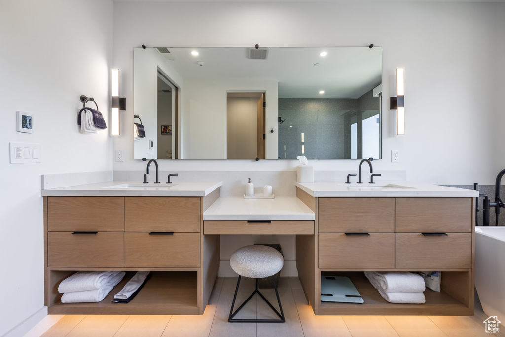 Bathroom with tile patterned flooring, vanity, and a shower with door