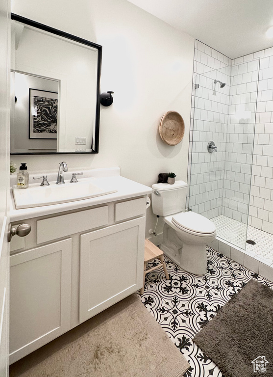 Bathroom with tile patterned floors, an enclosed shower, vanity, and toilet