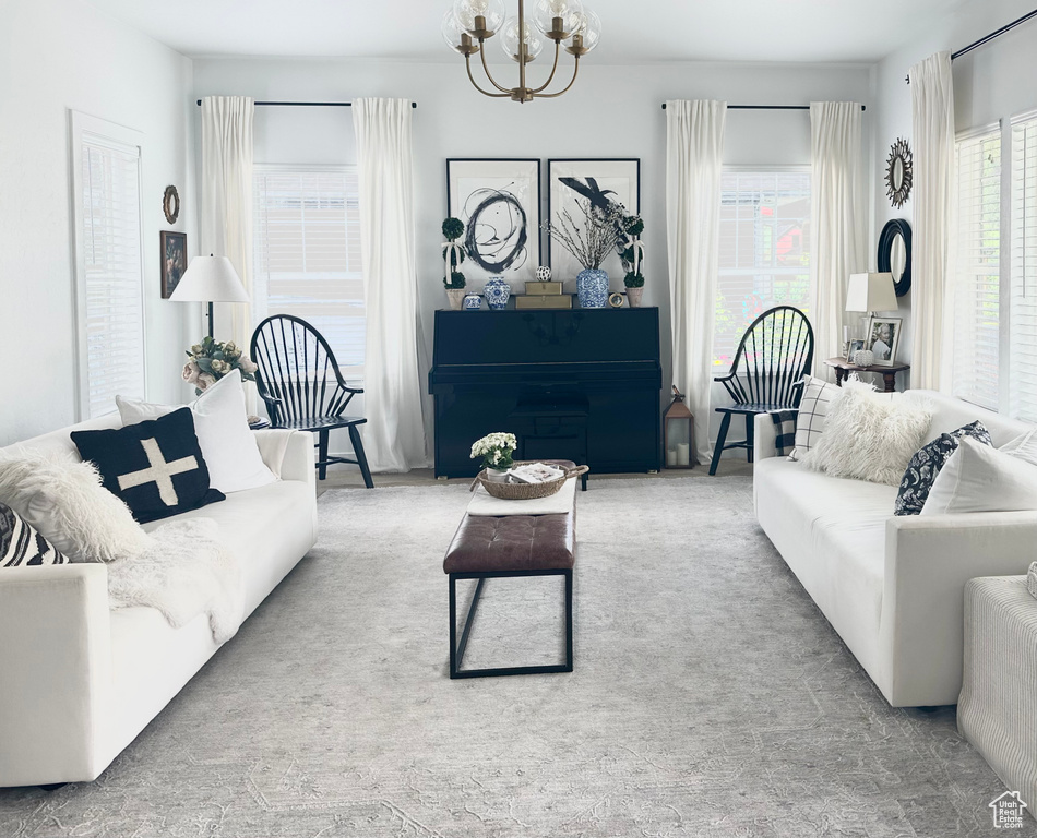 Living room featuring light carpet and an inviting chandelier