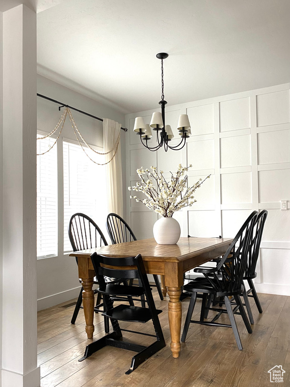 Dining space featuring an inviting chandelier and dark wood-type flooring