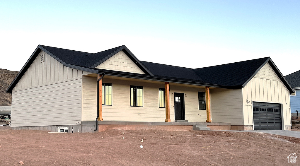 Modern inspired farmhouse with a garage and covered porch