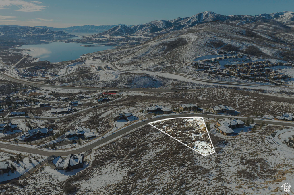 Snowy aerial view with property boundaries highlighted and a water and mountain view