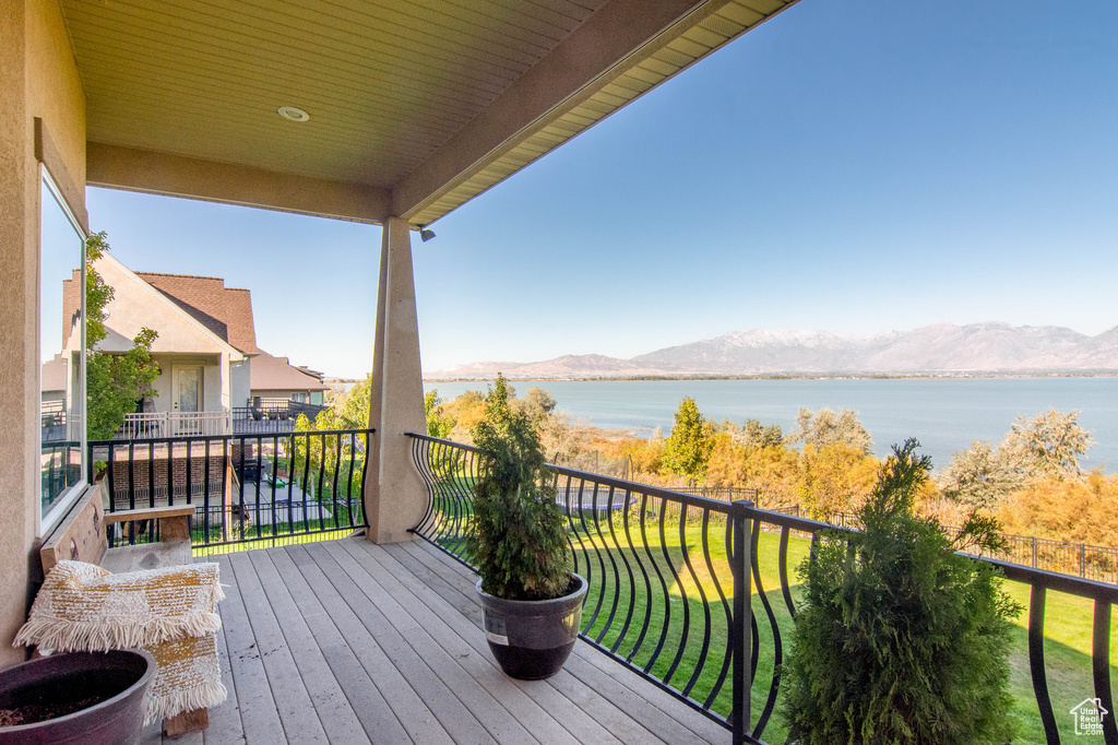 Balcony featuring a water and mountain view