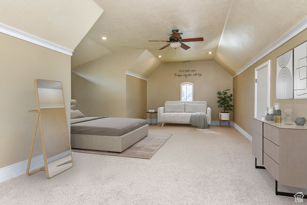 Bedroom featuring a textured ceiling, vaulted ceiling, ceiling fan, and light colored carpet