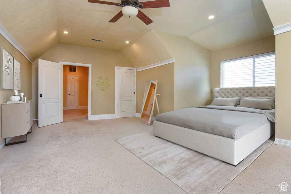 Bedroom with a textured ceiling, lofted ceiling, carpet floors, ornamental molding, and ceiling fan