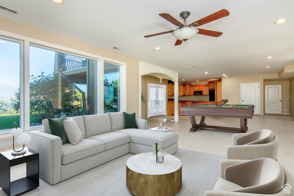 Carpeted living room featuring pool table, a textured ceiling, and ceiling fan